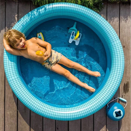 un baiat se joaca fericit in piscina